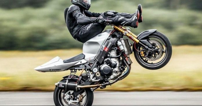 Мотоциклист установил рекорд скорости по езде на заднем колесе, сидя ногами вперед